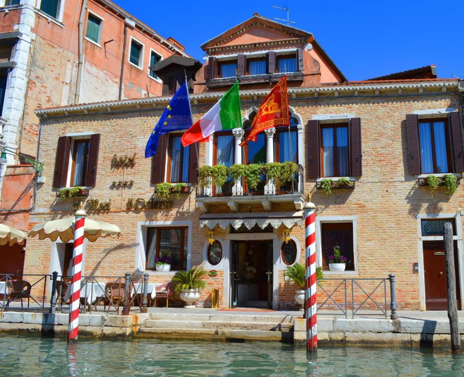 威尼斯东方魔力酒店的水面上的建筑,前面有旗帜