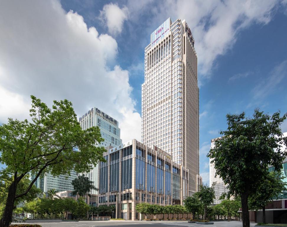 深圳Crowne Plaza Shenzhen Futian, Near by Futian Station and Coco Park, Outdoor Heated Pool的一座高大的建筑,上面有标志