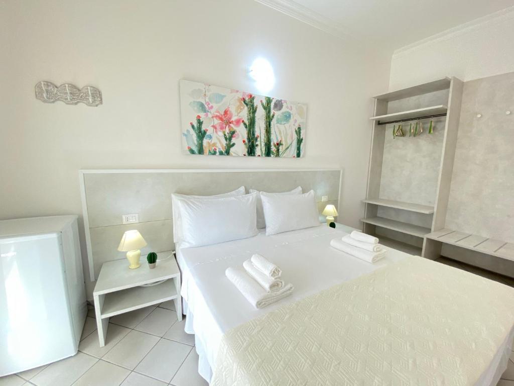 加利波利B&B Fellini Gallipoli的卧室配有白色的床和2条毛巾