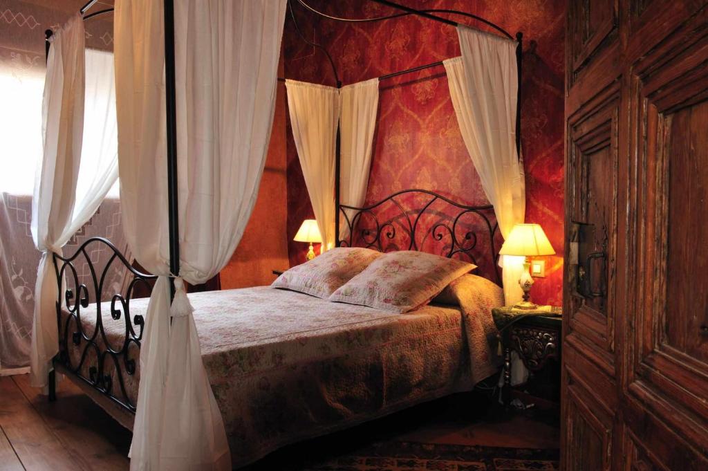 米兰韦尔莫拉达寺乡村民宿的一间卧室配有一张带天蓬的大床