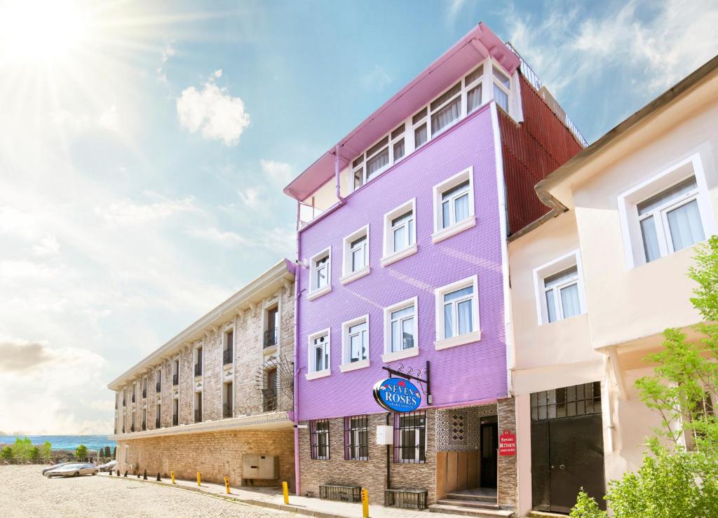 伊斯坦布尔SEVEN ROSES APART HOTEL的街道边的紫色建筑