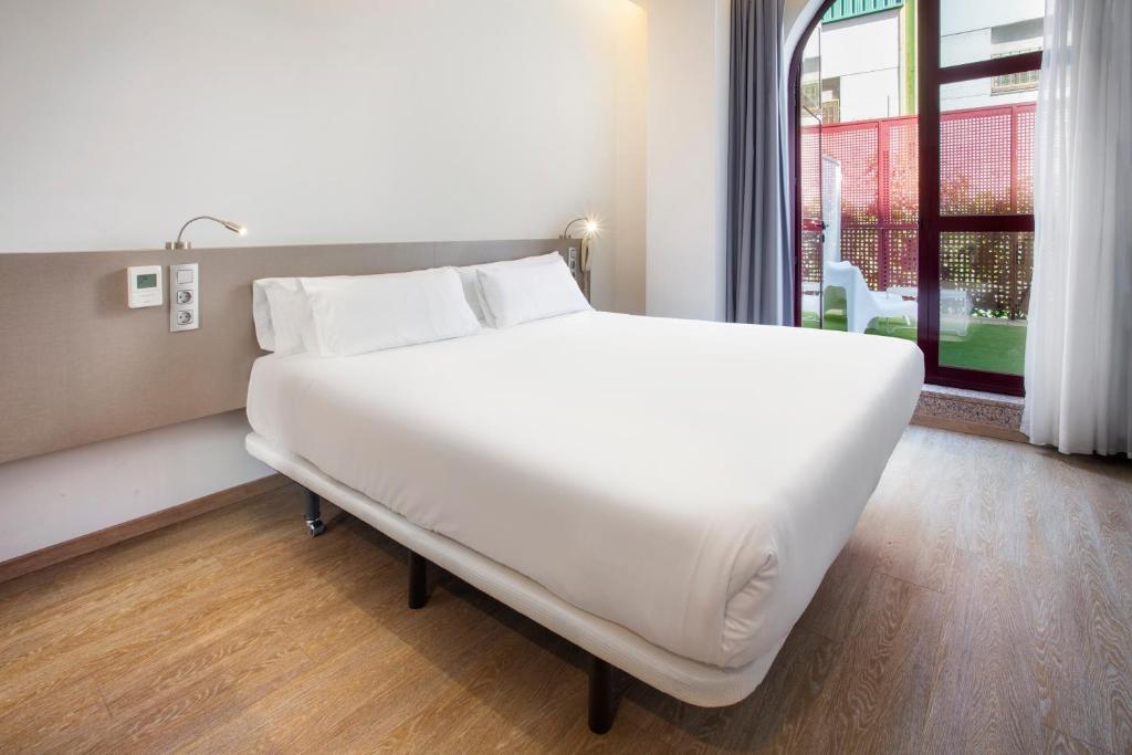 富恩拉夫拉达B&B HOTEL Madrid Fuenlabrada的窗户客房内的一张大白色床