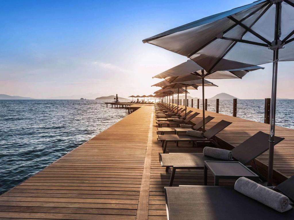 图尔古特雷斯博德鲁姆海滩瑞士度假酒店的长长的码头,上面有椅子和遮阳伞