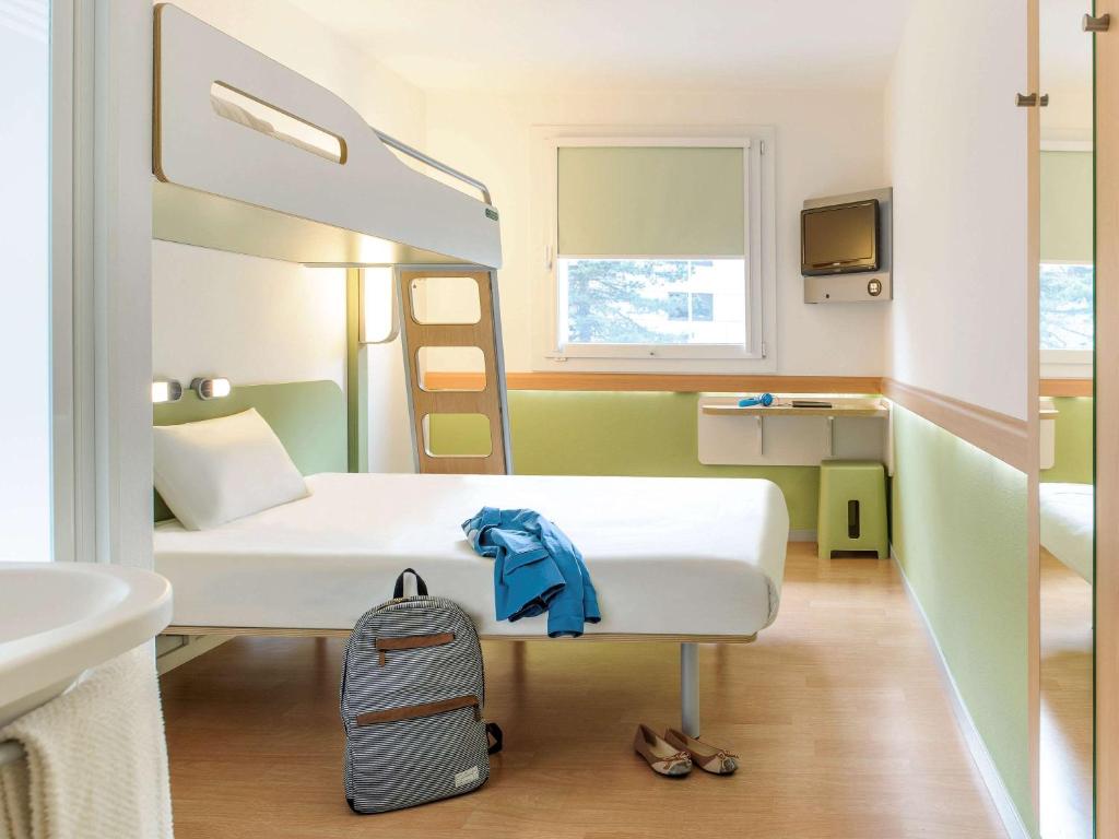 隆勒索涅ibis Budget Lons-le-Saunier的一间医院房间,配有床和背包