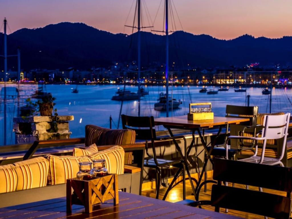 马尔马里斯Sunset Boutique Hotel Marmaris的阳台配有桌椅,享有海港的景致。