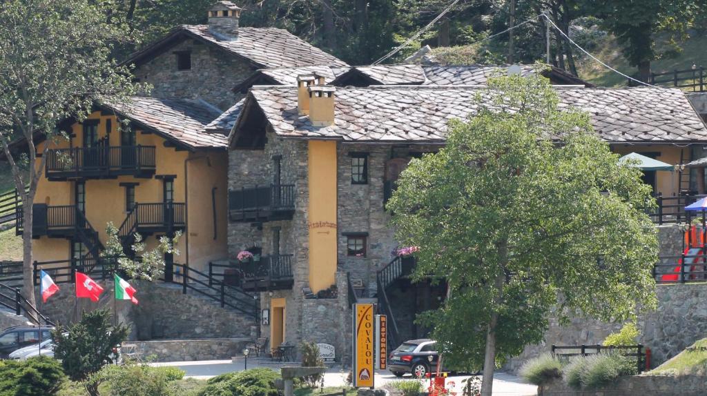 安泰伊-萨伊恩特-安德尔埃Residence Covalou的前面有两面旗帜的石头房子
