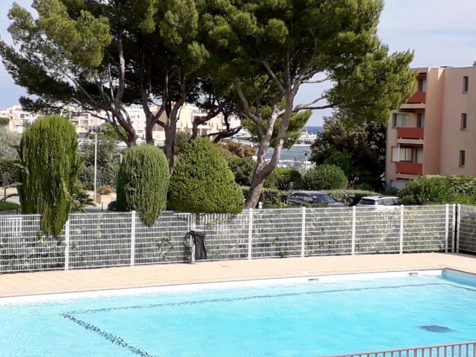 博尔马斯·莱斯·米默萨斯My Little Provence Bormes Les Mimosas的一个带栅栏和树木的蓝色游泳池