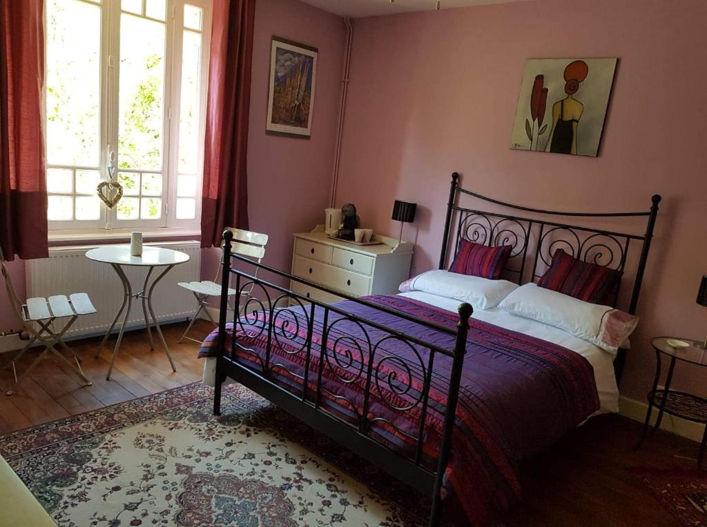 Ségur-le-ChâteauLes Charrons的卧室配有床、桌子和窗户。