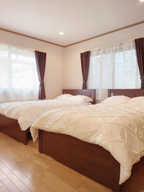 松户市Young House的卧室设有两张床,带两个窗户
