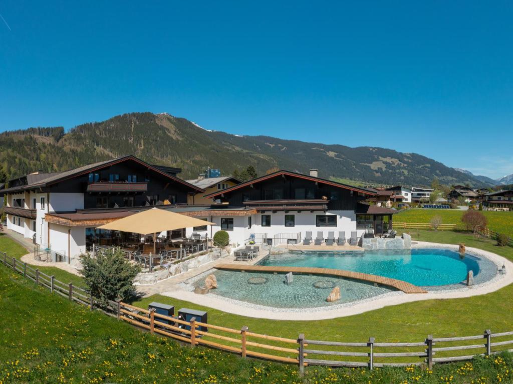 迈斯霍芬Hotel Quehenberger的度假村设有大型游泳池,背景为山脉