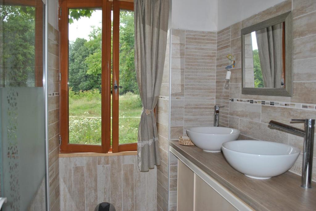 CoursacEn plein air的一间带两个盥洗盆和窗户的浴室