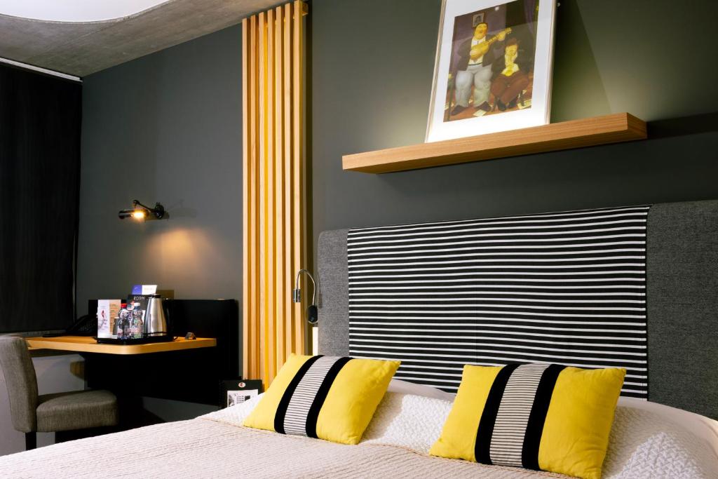 马蒂尼威尔马蒂尼精品酒店的一间卧室配有一张带黄色和黑色枕头的床