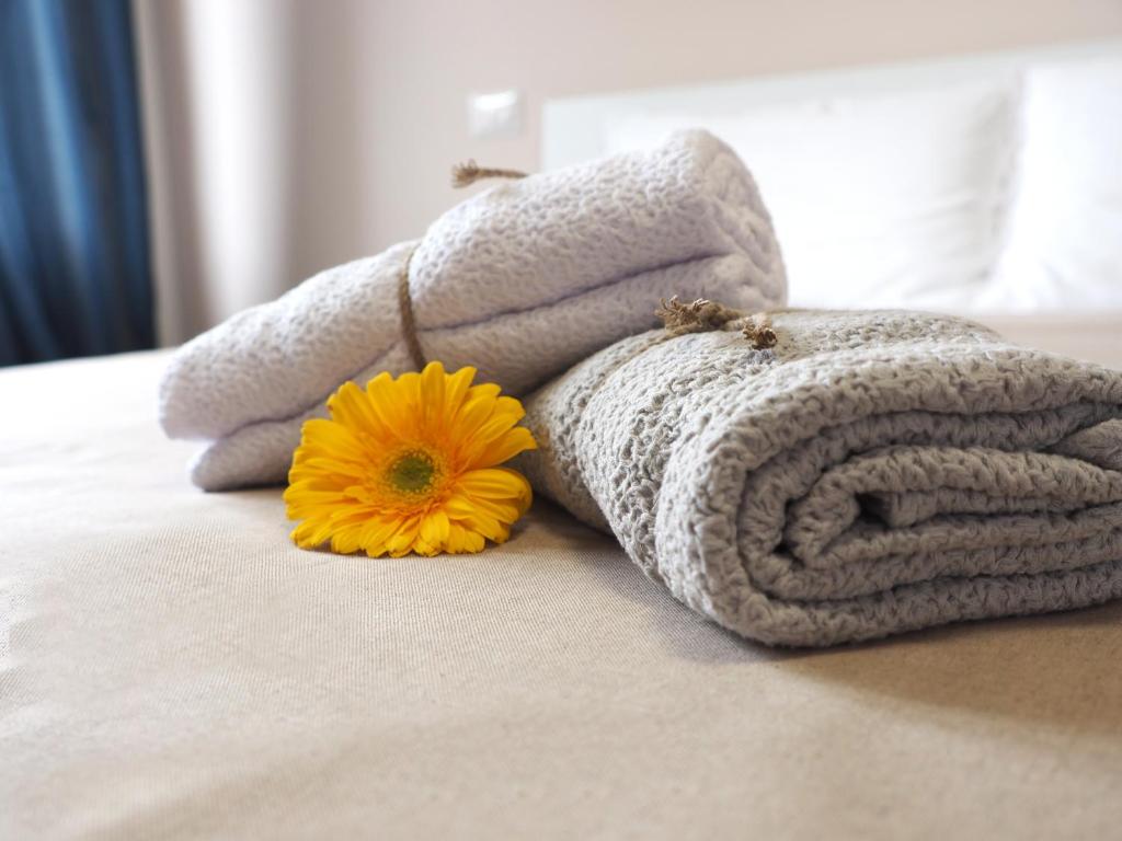 阿尔巴·阿德里亚蒂卡B&B Linae - Residence的床上有一大堆毛巾和一朵黄色花