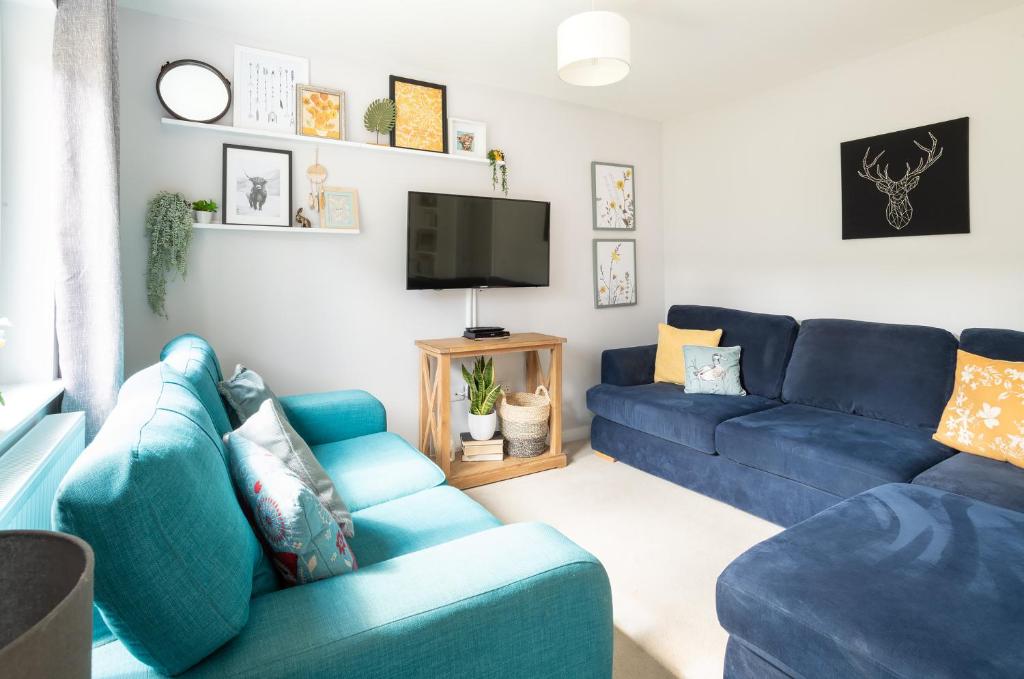 因弗内斯Lily Bank House的客厅配有蓝色的沙发和电视