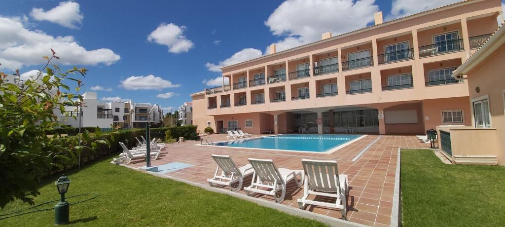阿尔沃尔Casa d'Alvor的一座带游泳池和椅子的酒店和一座建筑
