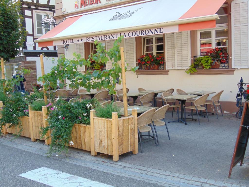 维桑堡维桑布尔拉卡尼酒店的人行道上的餐厅,设有桌椅和植物