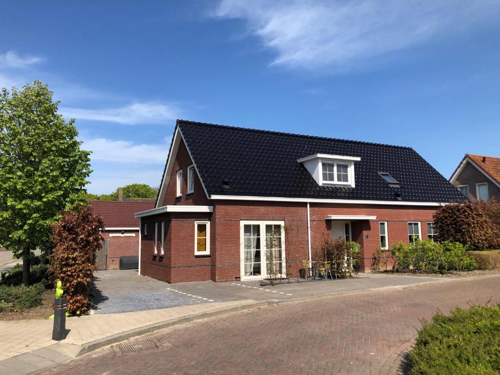弗劳温普尔德Etoile aan Zee的黑色屋顶红砖房子