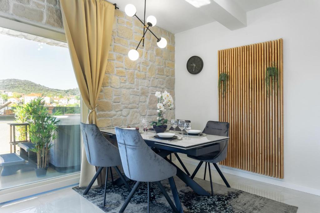 萨利TEONA Luxury Apartment with jacuzzi and terrace sea view的一间带桌子和四把椅子的用餐室