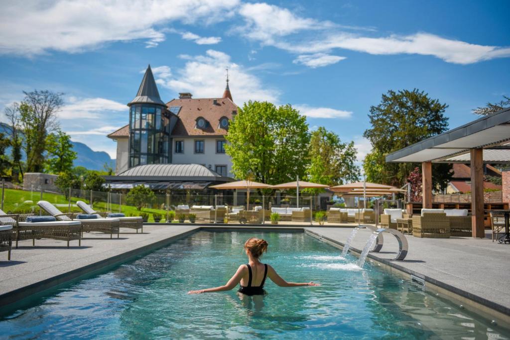 艾克斯河畔格雷西Château Brachet的度假胜地游泳池中的女人