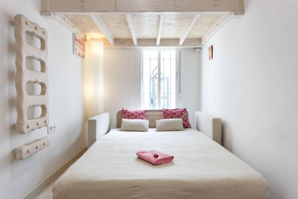 科尼尔-德拉弗龙特拉PRECIOSO Y PEQUEÑO LOFT CENTRO DE CONIL的一间设有一张大床的房间,上面有粉红色的鞋