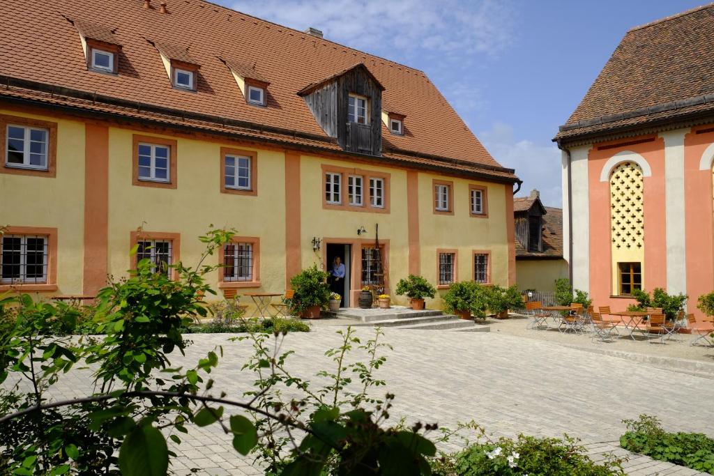 GnotzheimGentner - Hotel garni的一座黄色的大建筑,设有砖砌庭院