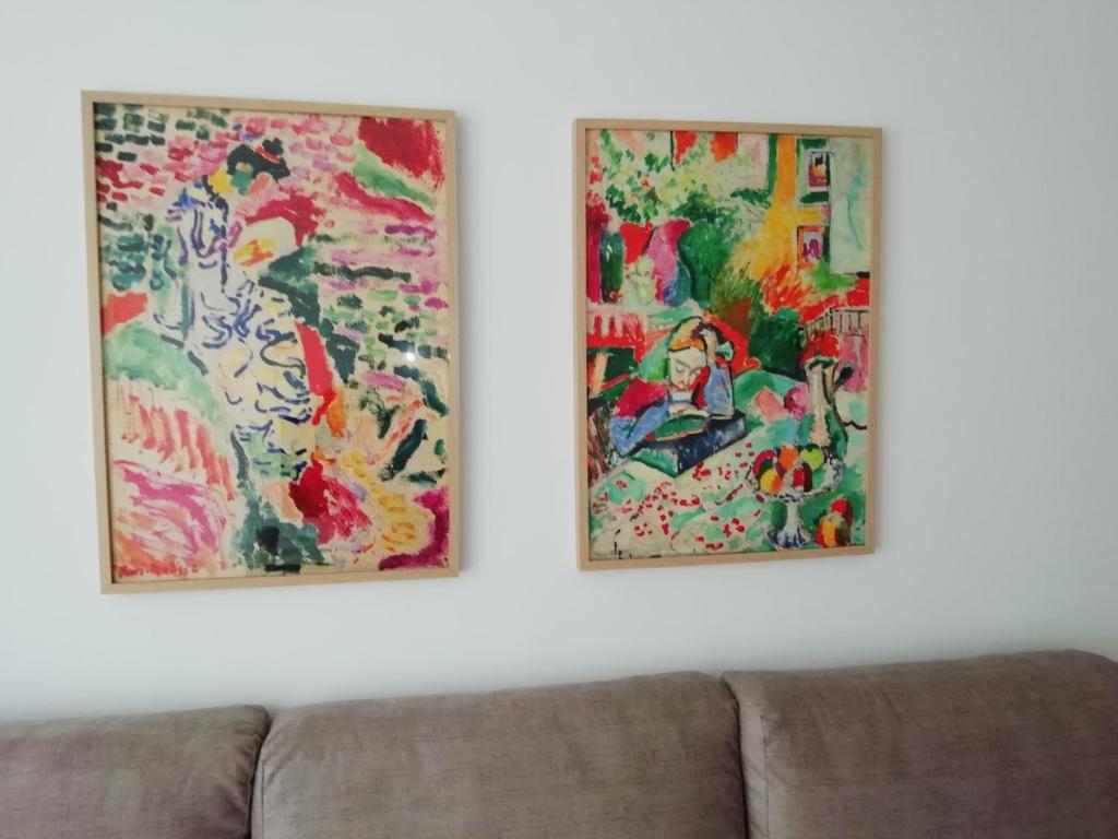 比利亚维西奥萨Apartamento Conlledo的两幅画挂在沙发旁边的墙上