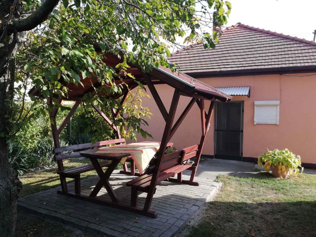 鲍洛通费尼韦什Holiday home in Balatonfenyves 38430的餐桌和凉亭下的长凳