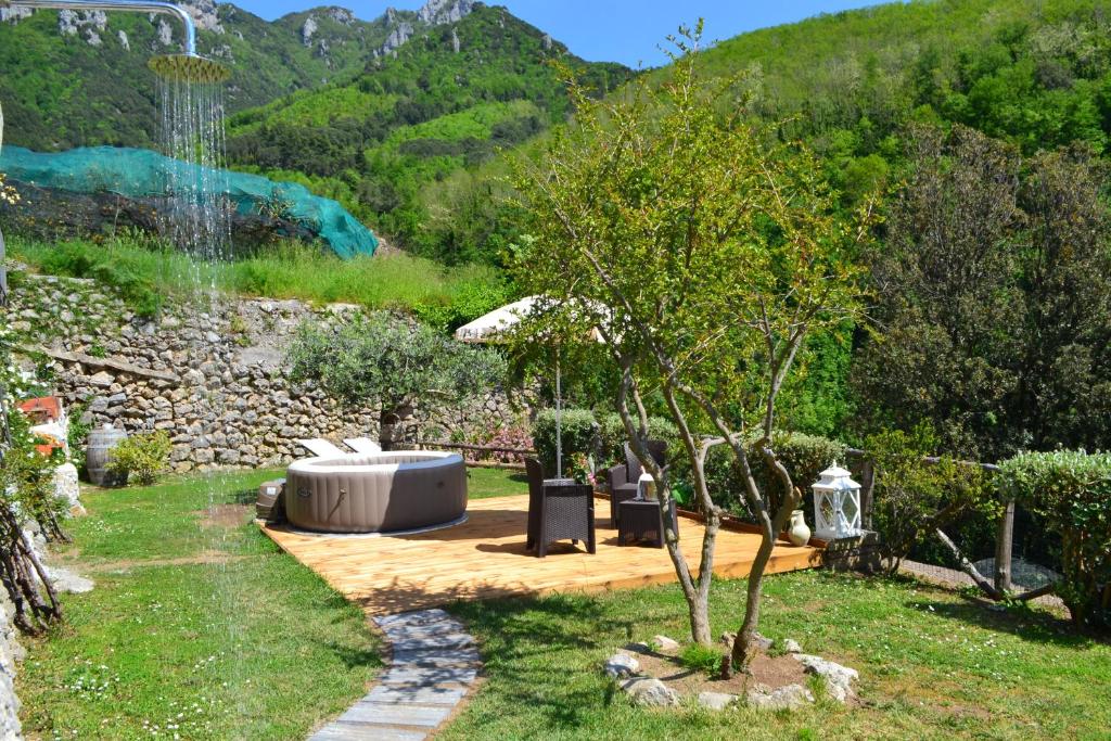 特拉蒙蒂Villa Le Volte Antiche的一个带热水浴缸和一棵树的花园