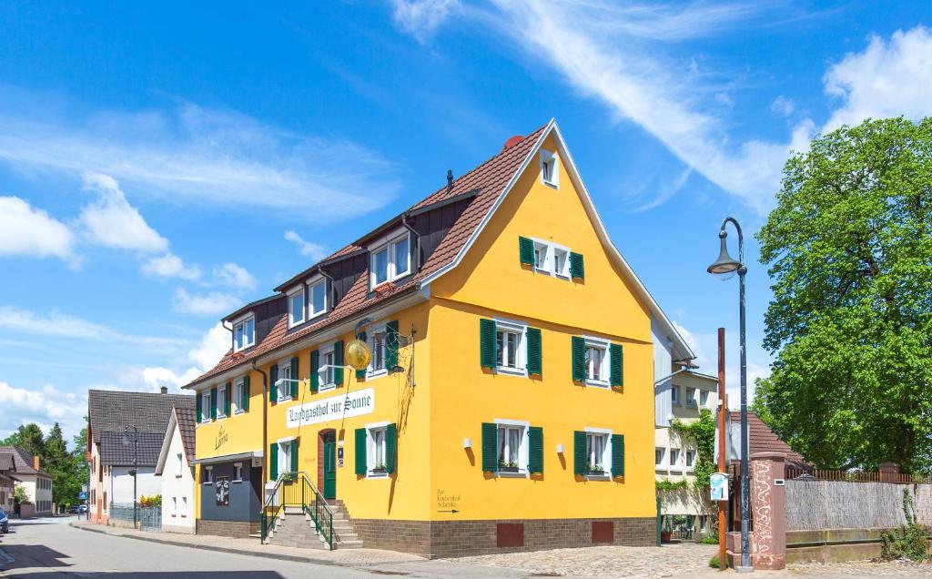 奥根Landgasthof zur Sonne的一条黄色的街道上,有棕色屋顶的建筑