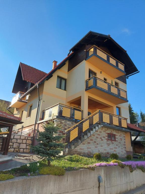 兹拉蒂博尔Apartments Monte Vista Zlatibor的前面有楼梯的大房子