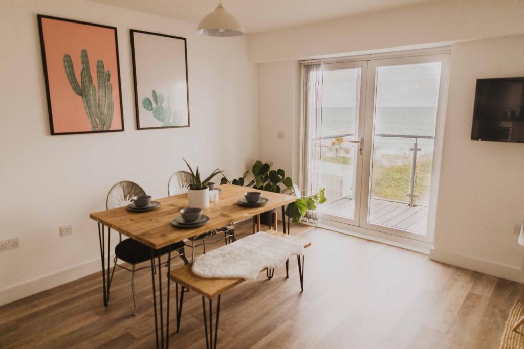 纽基Ocean 1- Sea View apartment, Fistral Beach Newquay的一间带桌子和大窗户的用餐室
