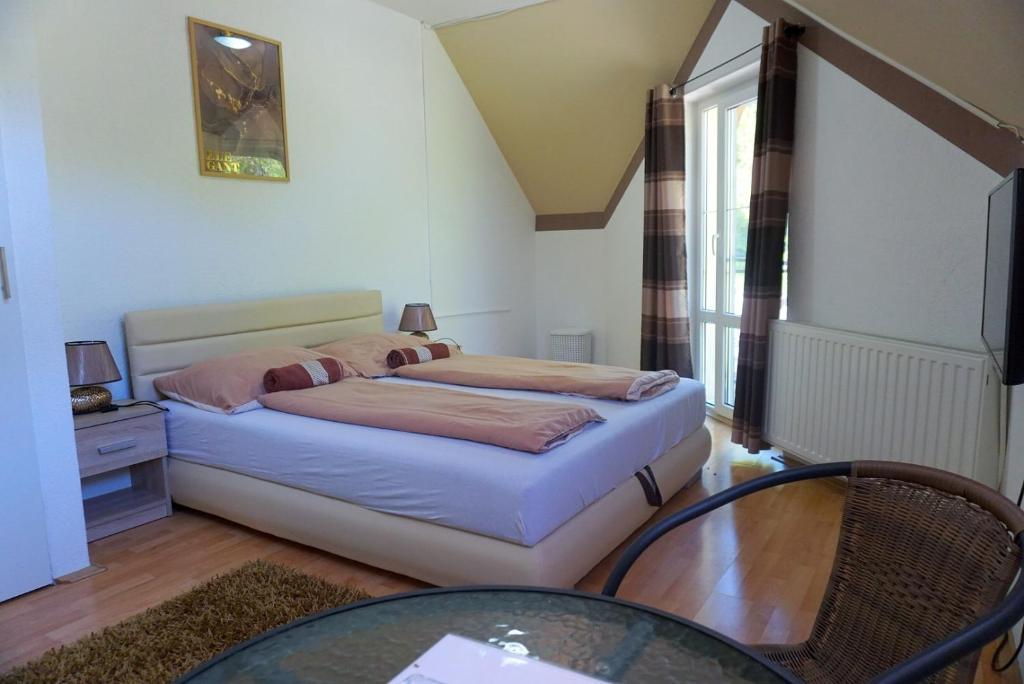 沙托劳尔尧乌伊海伊Berg Szállás的一间小卧室,配有一张床和一张玻璃桌