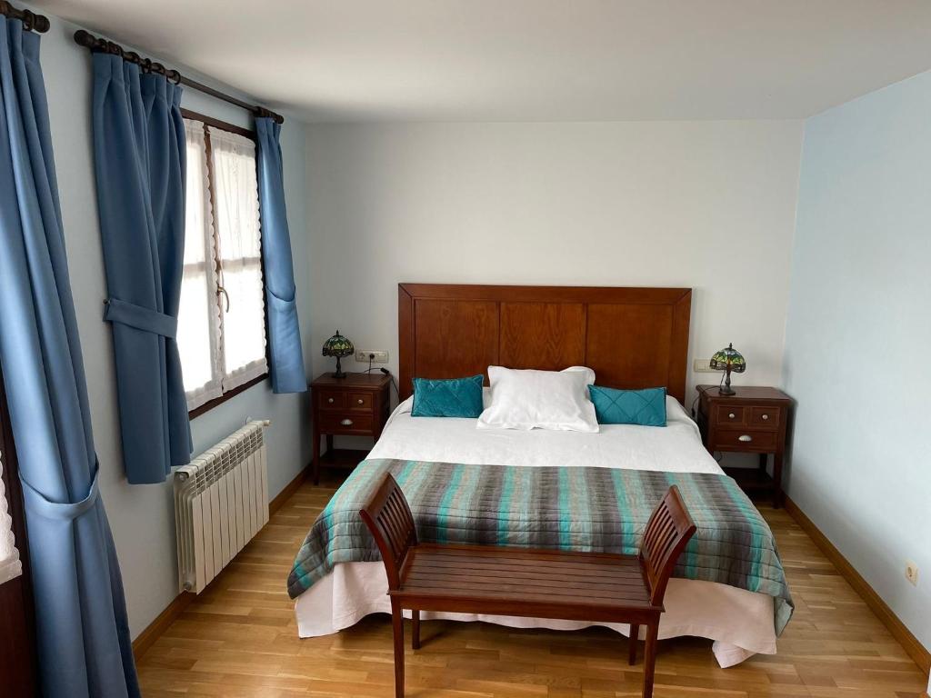 RalesLA CASONA DE RALES VILLAVICIOSA的一间卧室配有一张带蓝色窗帘的大床