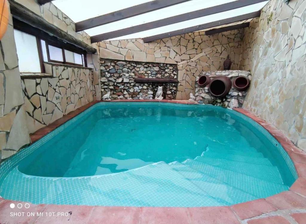 弗里希利亚纳Villa Jardin piscina climatizada的一座石墙房子里的一个大型游泳池