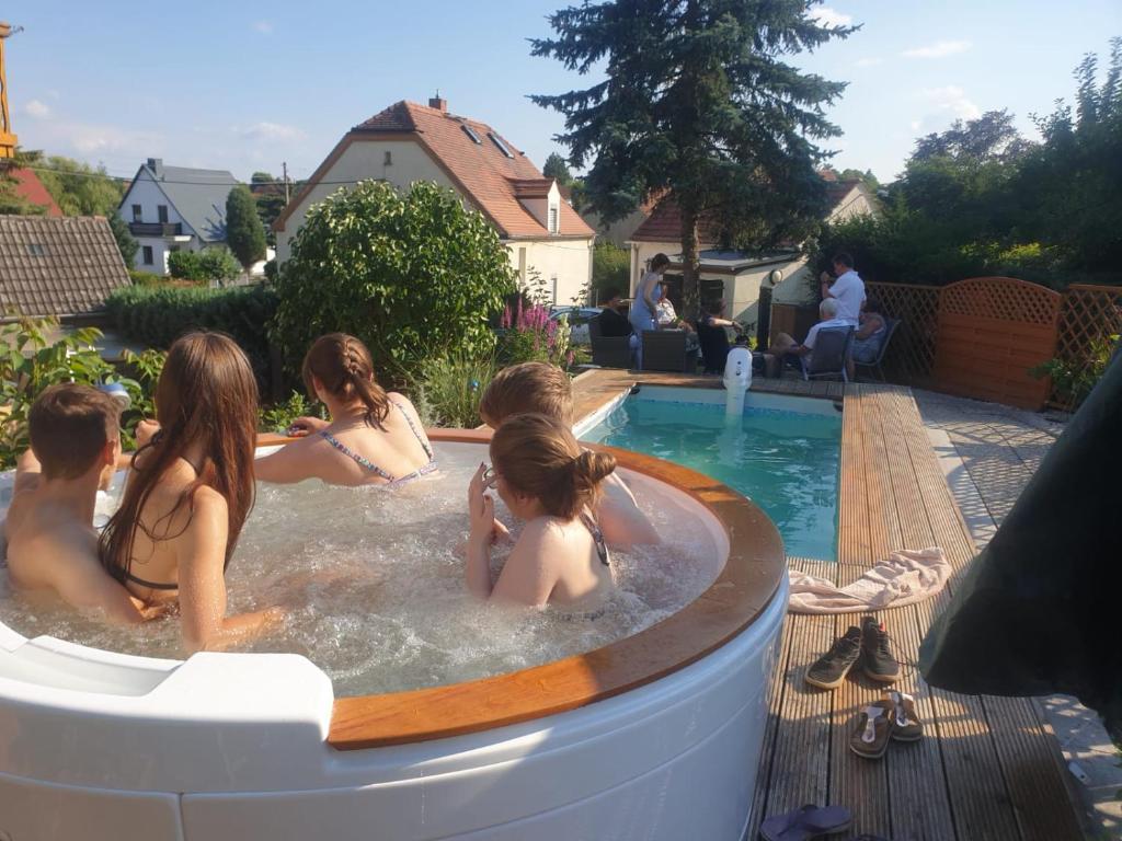 莫里茨堡Ferienwohnung Moritzburg mit Pool的一群人在后院的热水浴缸中