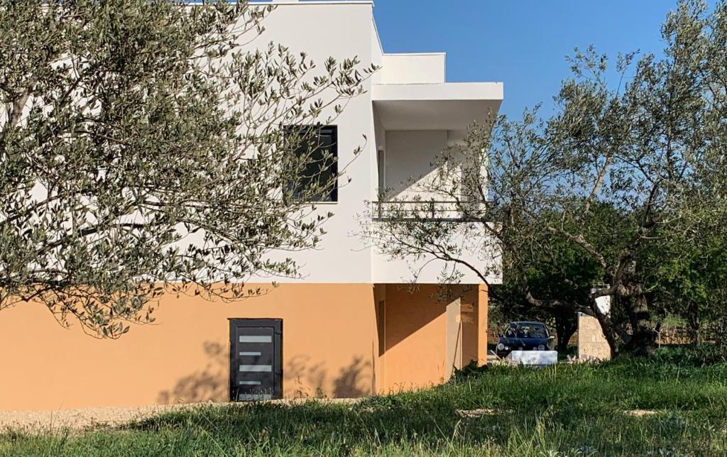 德拉格MiaBella Resort的一座白色和橙色的房子,在田野里停车