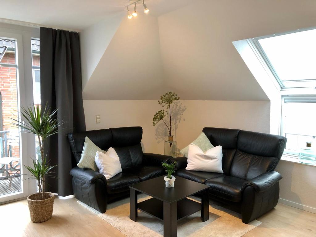 奥尔登堡Apartment in Uni- und Citynähe的客厅配有黑色真皮沙发和桌子
