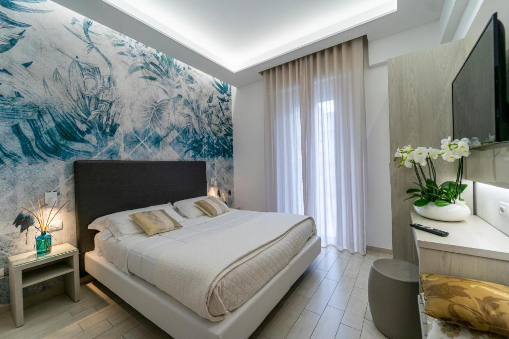 里米尼斯特拉多罗酒店的卧室配有一张床,墙上挂有绘画作品