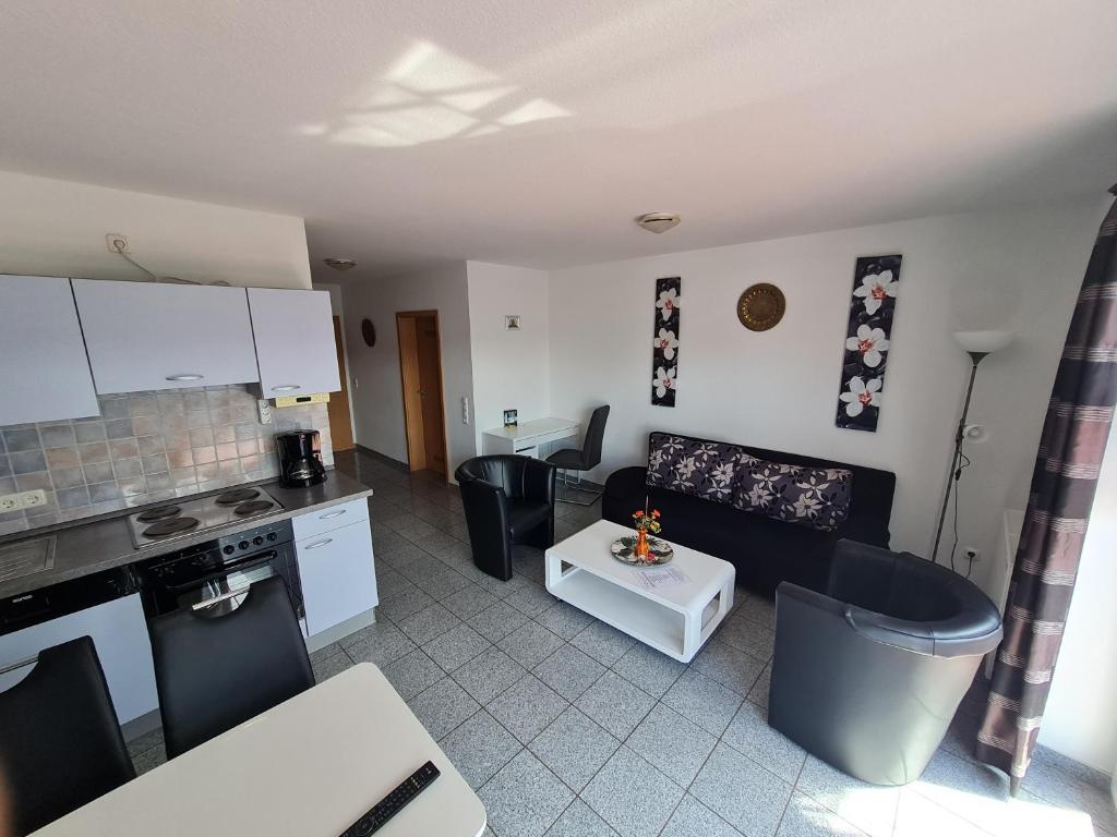 诺登Ferienwohnungen Saida Wohnung 5的厨房以及带沙发和桌子的客厅。