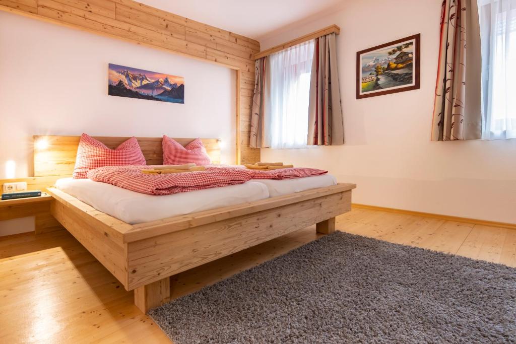 Au an der Donau多瑙河河畔露营地及旅馆的卧室配有带粉红色枕头的大型木质床