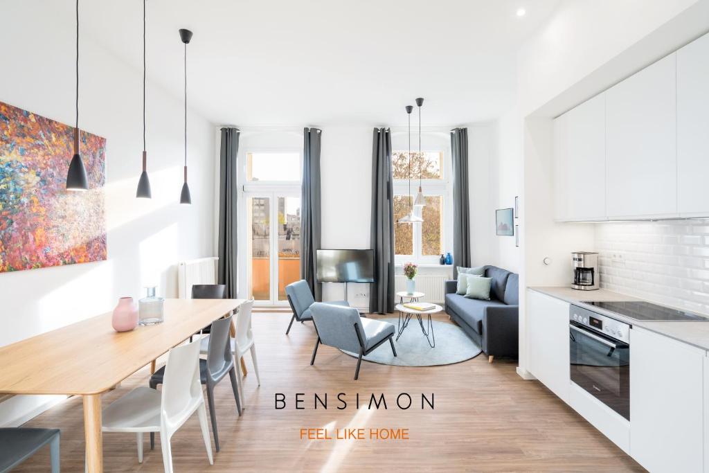 柏林BENSIMON apartments Mitte/Wedding的厨房以及带桌椅的起居室。