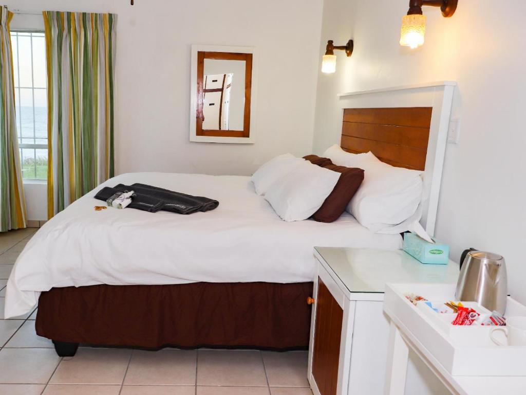 爱德华港Black Rock Lodge的一间卧室配有一张带白色床单的大床