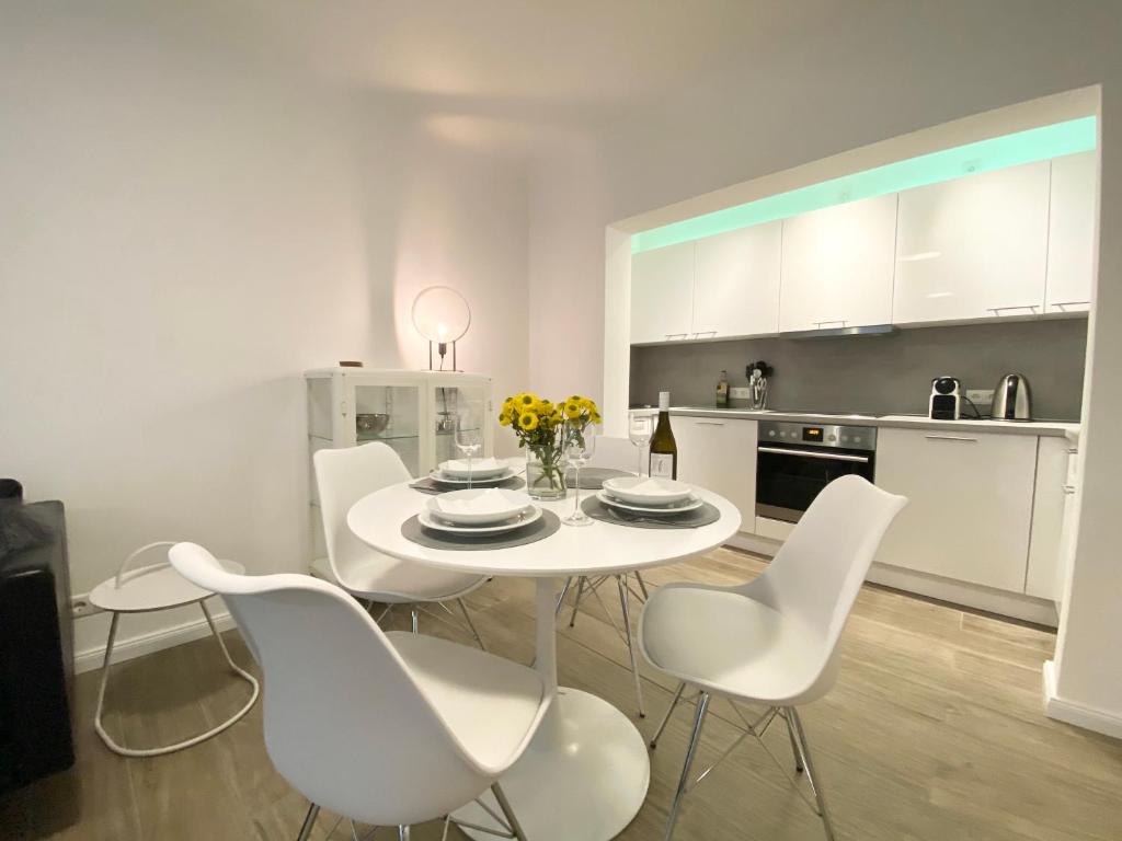 汉堡3-Raum Apartment Quartier57 Hamburg-Eppendorf的白色的用餐室配有白色的桌椅