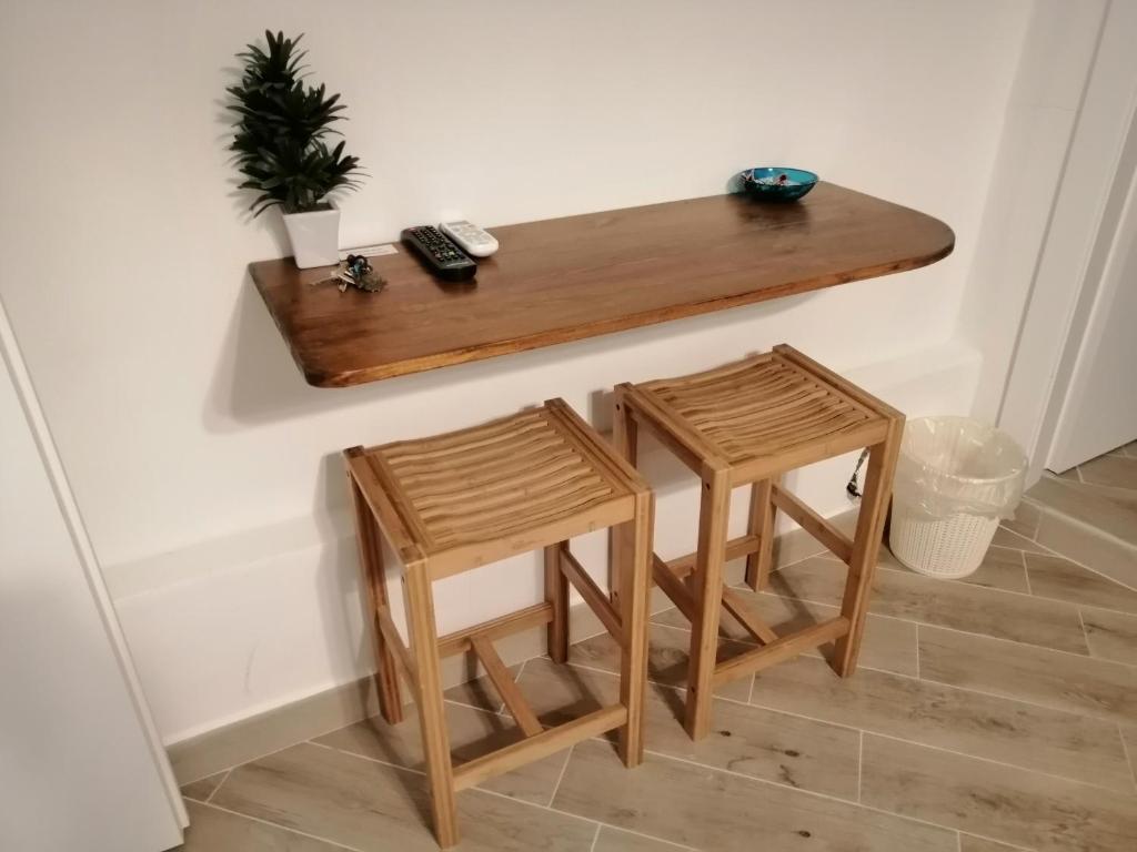 皮昂比诺Tre Orologi的一张桌子和两张凳子坐在墙上