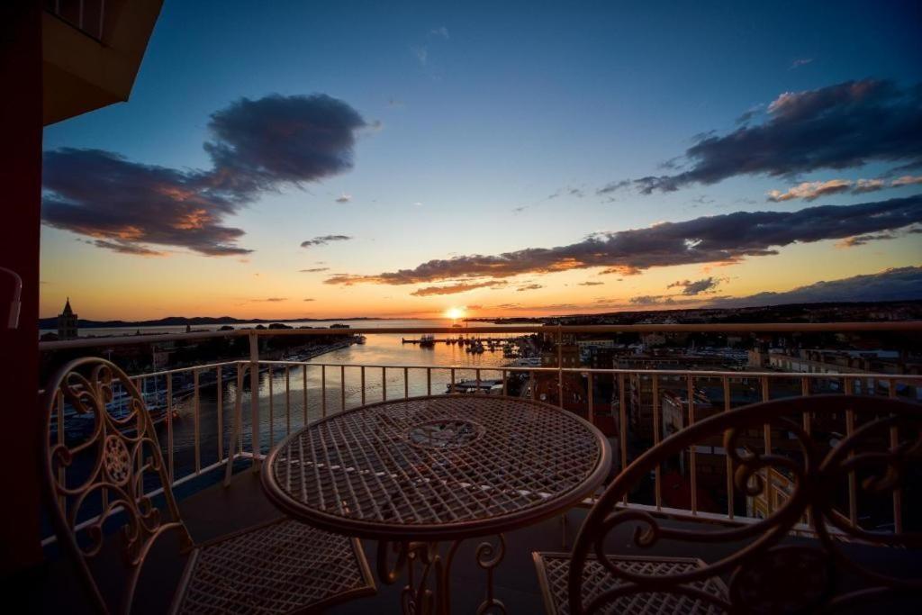 扎达尔Aurora & Tramonto的阳台的桌椅享有日落美景