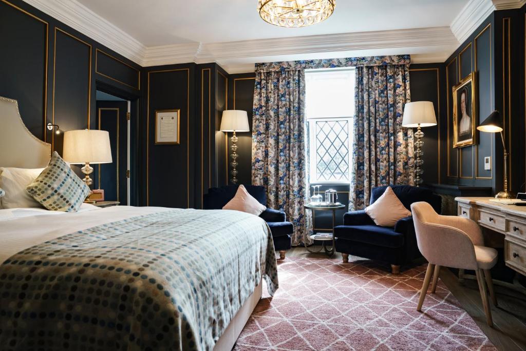 泰晤士河畔金斯顿白鹿酒店的一间卧室配有一张床、一张书桌和一个窗户。
