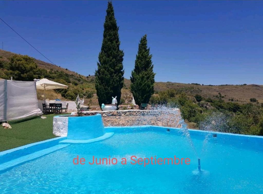 EnixLas Tres Patas Complejo Rural的庭院里一个带喷泉的蓝色游泳池