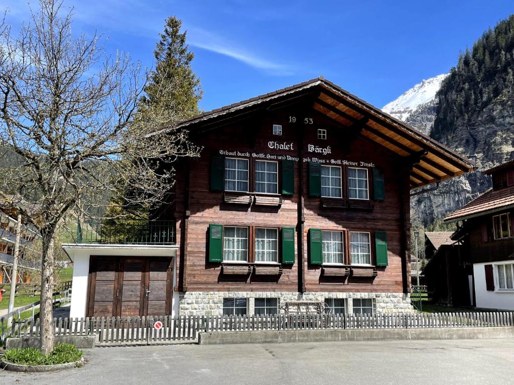 坎德施泰格Familienferien im Chalet Bärgli Kandersteg的一座大型木屋,前面设有围栏