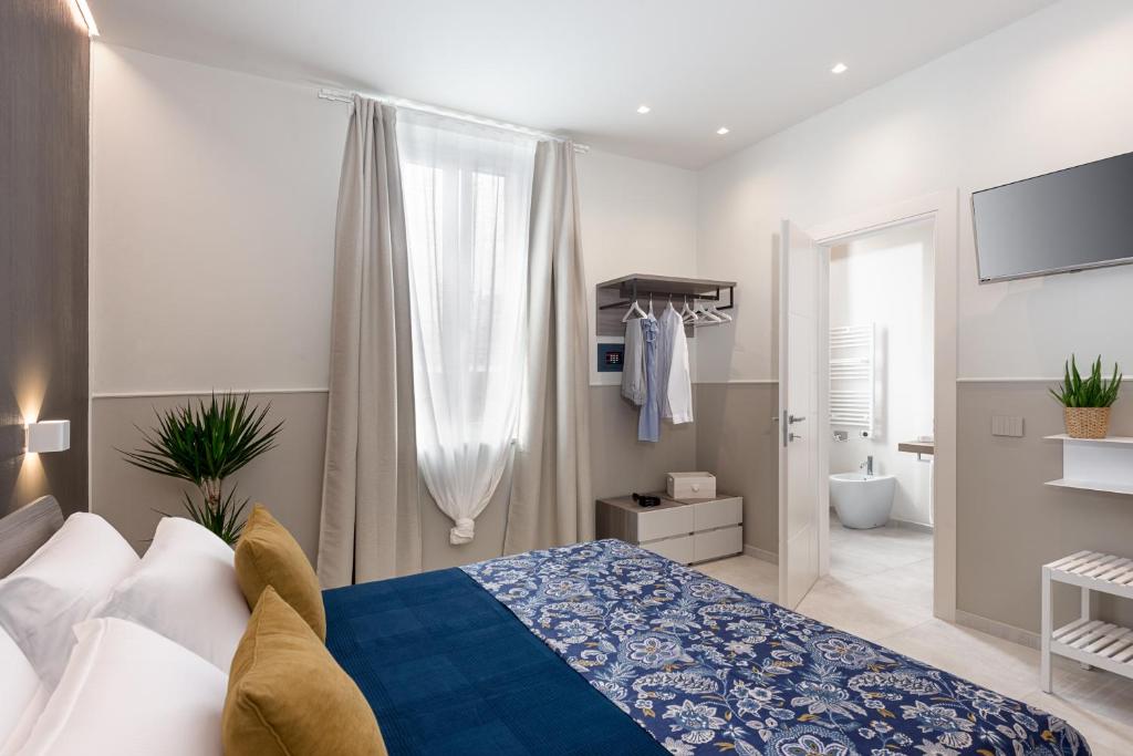 福洛尼卡Oltremare的一间带蓝色和白色床的卧室以及一间浴室。