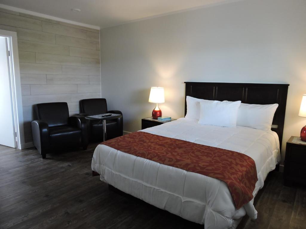 克兰布鲁克阿尔莫苑汽车旅馆的酒店客房带一张大床和两张椅子